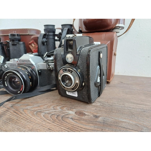 716 - A collection of cameras and binoculars to include Mark Scheffel 20x50, Canon AV-1 35mm SLR fitted wi... 