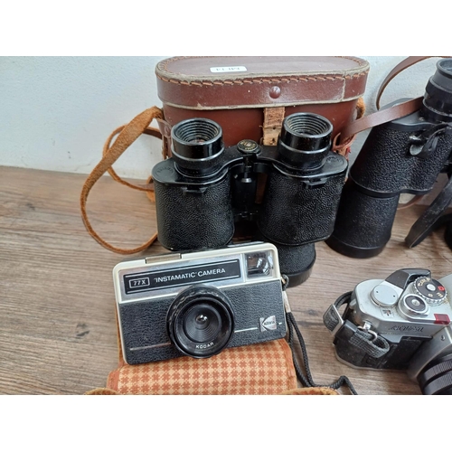 716 - A collection of cameras and binoculars to include Mark Scheffel 20x50, Canon AV-1 35mm SLR fitted wi... 