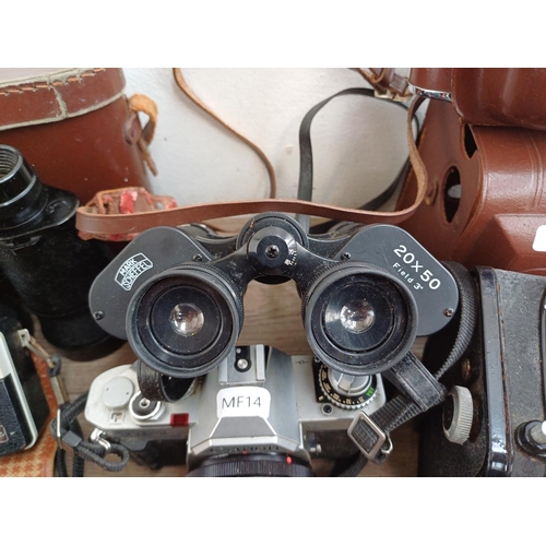 716 - A collection of cameras and binoculars to include Mark Scheffel 20x50, Canon AV-1 35mm SLR fitted wi... 