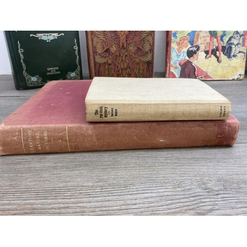 563 - Twelve antique and later hardback books to include The Works of Charlotte and Emily Bronte, Birds of... 