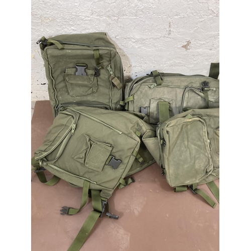 570 - A large quantity of military style rucksacks together with a St. Andrews Ambulance Corps peaked cap