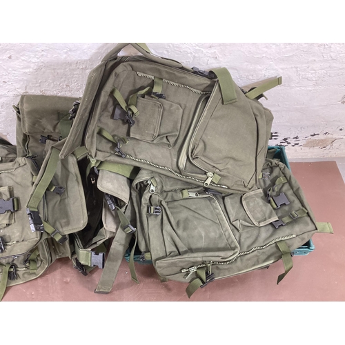 570 - A large quantity of military style rucksacks together with a St. Andrews Ambulance Corps peaked cap