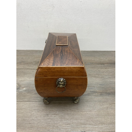 594 - A George III inlaid rosewood sarcophagus tea caddy with brass lion paw handles, mythical fish feet a... 