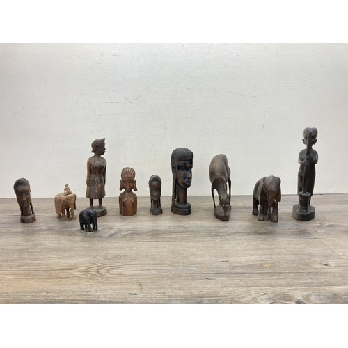 602 - A collection of carved treen figurines to include African Trible style busts, elephants etc.