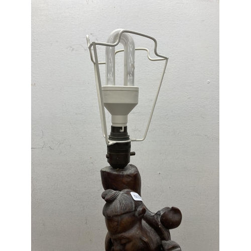 609 - A Chinese carved hardwood elder figural table lamp - approx. 55cm high (including bulb holder)