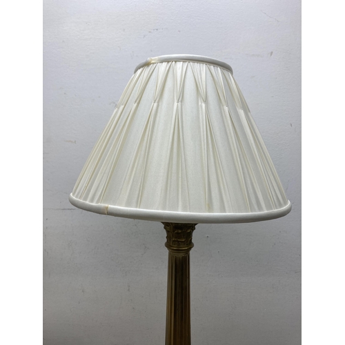 610A - A Laura Ashley Georgian style brass Corinthian table lamp with two cream shades