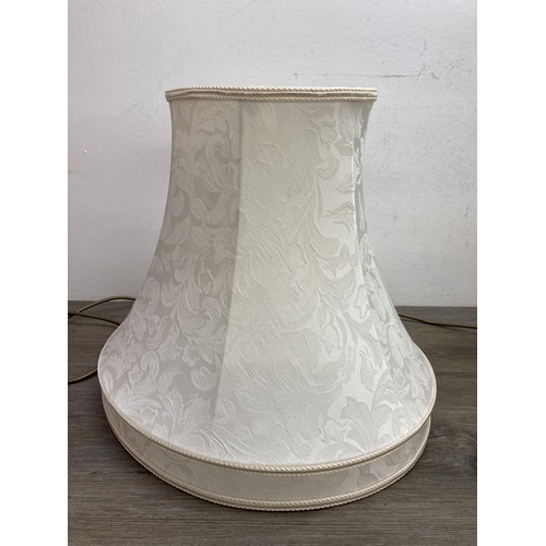 610A - A Laura Ashley Georgian style brass Corinthian table lamp with two cream shades