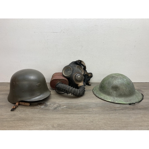 635B - Three pieces of militaria, one No.4 gas mask and two WWII helmets