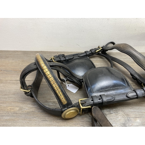 635C - Three pieces of vintage leather horse tack, driving saddle, full driving bridle with blinkers and lu... 