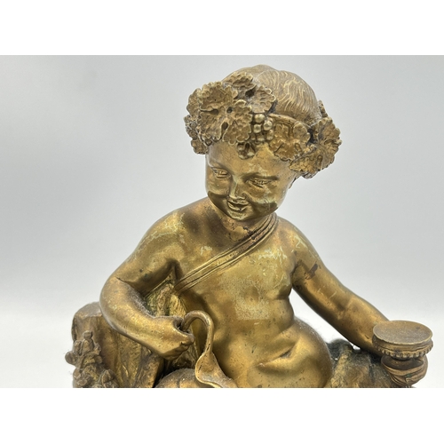 2291 - A Neoclassical style gilded cast metal figurine of a cherub - approx. 18cm high x 20cm wide