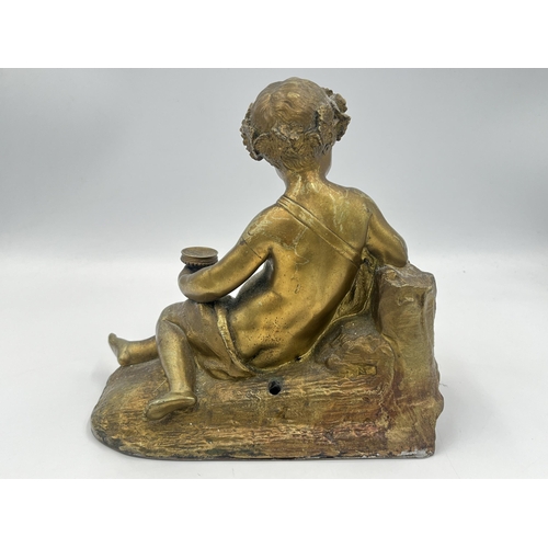 2291 - A Neoclassical style gilded cast metal figurine of a cherub - approx. 18cm high x 20cm wide