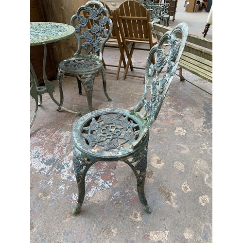 107 - A Victorian style green painted cast metal three piece patio set - table approx. 73cm high x 69cm di... 