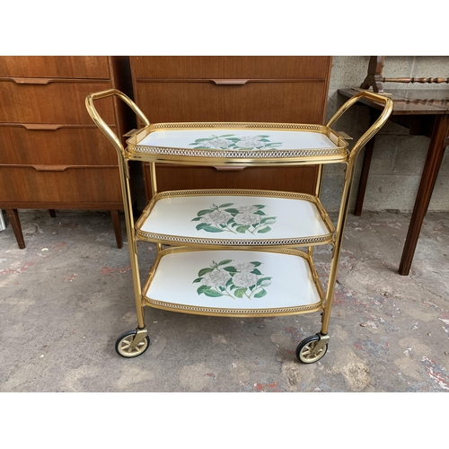 137 - A mid 20th century gilt metal and laminate three tier drinks trolley - approx. 78cm high x 39cm wide... 