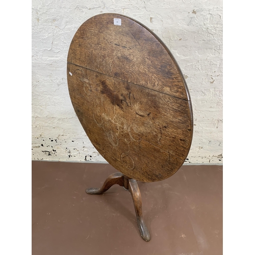 138 - A George III oak circular tilt top tripod occasional table - approx. 115cm high x 80cm diameter