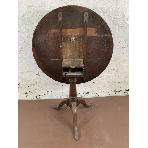 138 - A George III oak circular tilt top tripod occasional table - approx. 115cm high x 80cm diameter