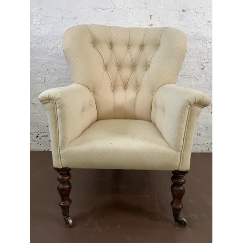140 - A Victorian fabric upholstered armchair on turned mahogany supports and brass castors - approx. 101c... 