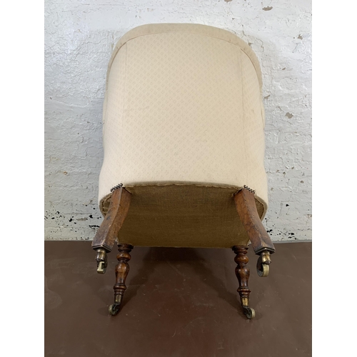 140 - A Victorian fabric upholstered armchair on turned mahogany supports and brass castors - approx. 101c... 