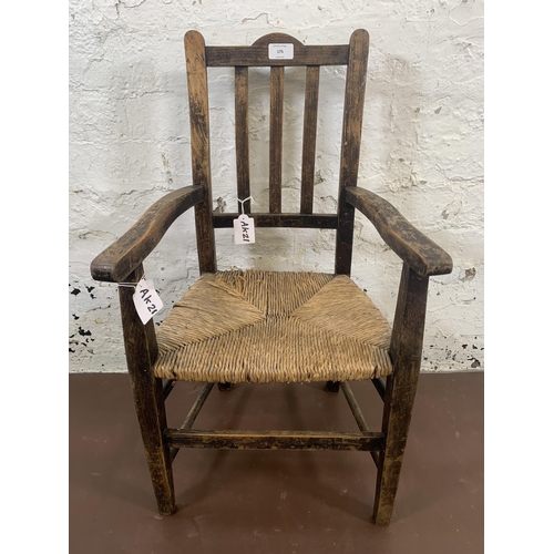 175 - An early 20th century beech and rush seated child's armchair