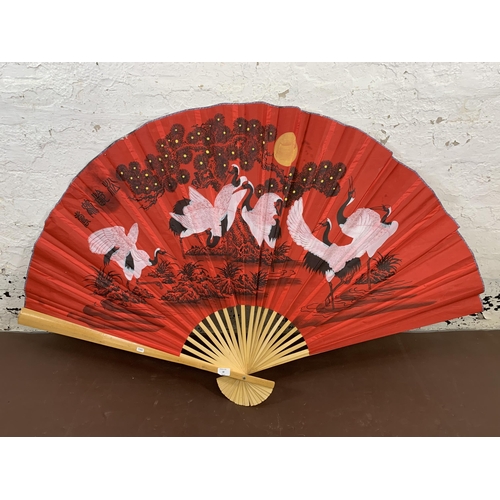 18 - An Oriental bamboo and hand painted red fabric fan - approx. 90cm high x 160cm wide