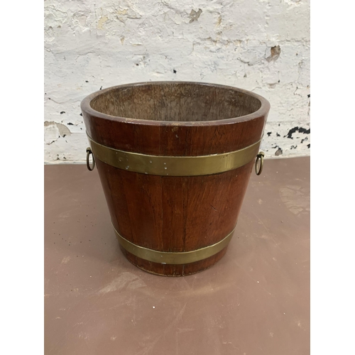 181 - Two coopered items, one teak and brass banded twin handled pail and one oak and metal banded child's... 