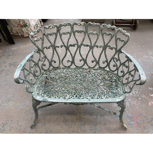 186 - Four pieces of green painted cast metal garden furniture, three chairs and one bench