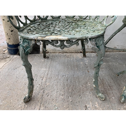 186 - Four pieces of green painted cast metal garden furniture, three chairs and one bench