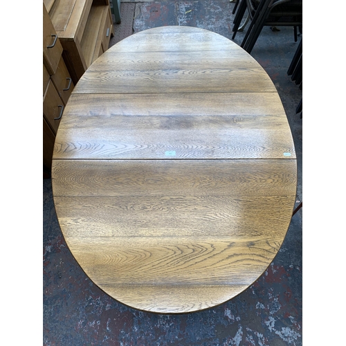 211 - A Georgian style oak drop leaf gate leg oval dining table - approx. 76cm high x 89cm wide x 133cm lo... 