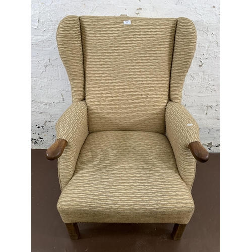 214 - A mid/late 20th century fabric upholstered and beech wingback armchair