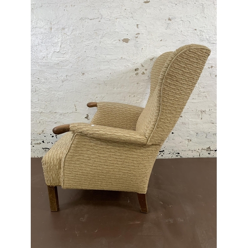 214 - A mid/late 20th century fabric upholstered and beech wingback armchair