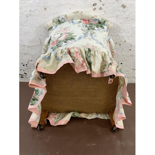 215 - An early 20th century floral fabric upholstered armchair