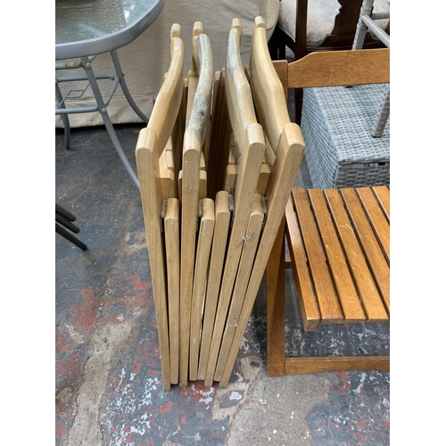 224 - Nine dining chairs, four black stacking and five beech folding