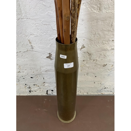 227 - A WWII brass shell case, dated 1944 together with six vintage walking sticks - shell case approx. 59... 