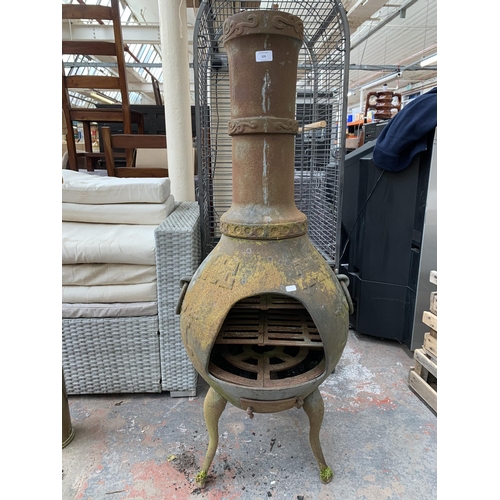 229 - A cast iron garden chiminea on tripod base - approx. 125cm high