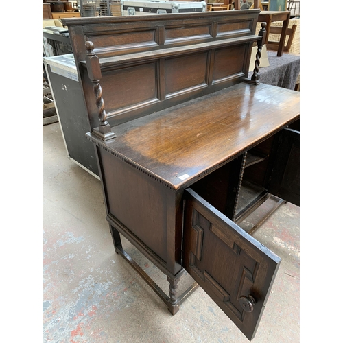 231 - An early 20th century oak sideboard on barley twist supports with lower stretcher, three cupboard do... 