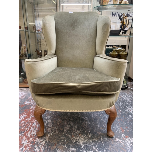 243 - A Georgian style green fabric upholstered wingback armchair on cabriole supports - approx. 98cm high... 