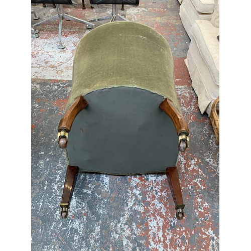 244 - An Edwardian green fabric upholstered armchair on mahogany tapered supports with ceramic and brass c... 