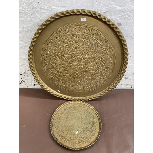 25 - Two Middle Eastern brass circular trays/chargers, one approx. 92cm diameter and one approx. 48cm dia... 