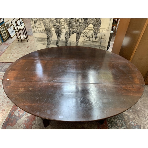 27 - A Georgian style solid oak drop leaf gate leg oval dining table on turned supports - approx. 76cm hi... 