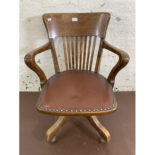 36 - A 1930s Angus of London beech and brown vinyl upholstered swivel desk chair on castors - approx. 82c... 