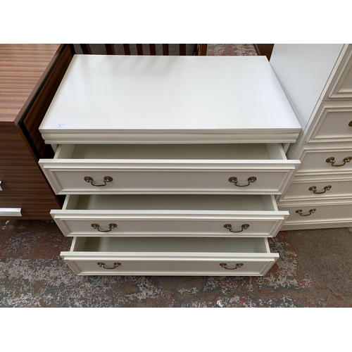 59 - A white laminate chest of drawers - approx. 65cm high x 81cm wide x 49cm deep