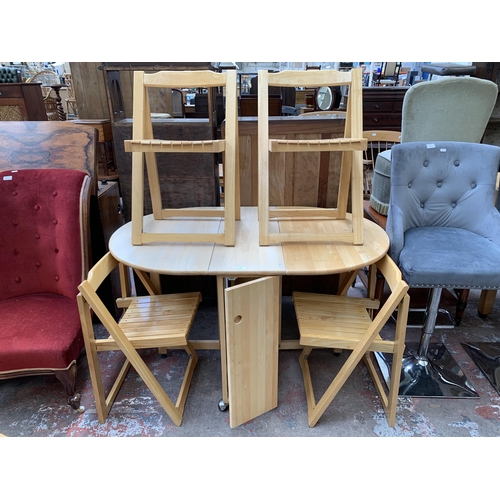 64 - A modern beech drop leaf gate leg space saving dining table and four folding chairs - approx. 76cm h... 