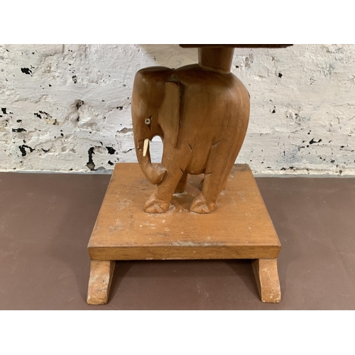 77 - A carved teak elephant design pedestal side table - approx. 35cm high x 30cm wide x 29cm deep