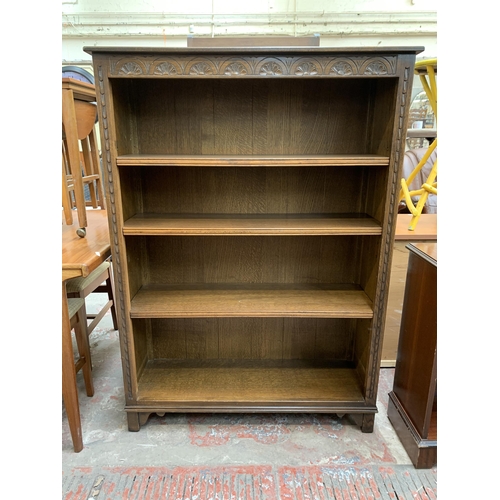 78 - A Jaycee carved oak four tier bookcase - approx. 135cm high x 98cm wide x 33cm deep