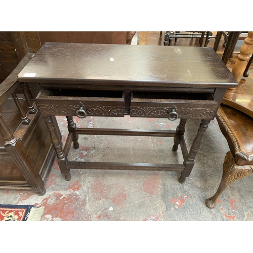 112 - A carved oak two drawer console table - approx. 74cm high x 78cm wide x 32cm deep