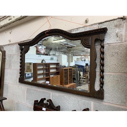 260 - An early 20th century oak framed bevelled edge overmantel mirror with barley twist supports - approx... 