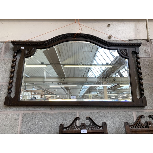 260 - An early 20th century oak framed bevelled edge overmantel mirror with barley twist supports - approx... 