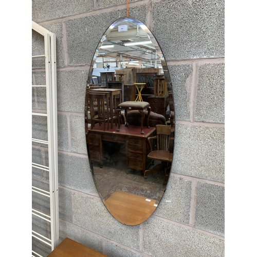 261 - A mid 20th century frameless bevelled edge oval wall mirror - approx. 95cm high x 45cm wide