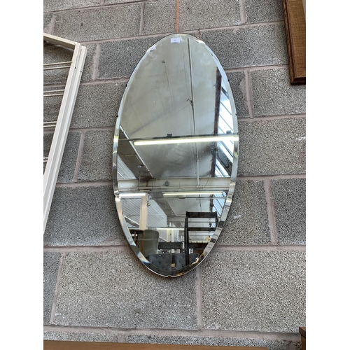 261 - A mid 20th century frameless bevelled edge oval wall mirror - approx. 95cm high x 45cm wide