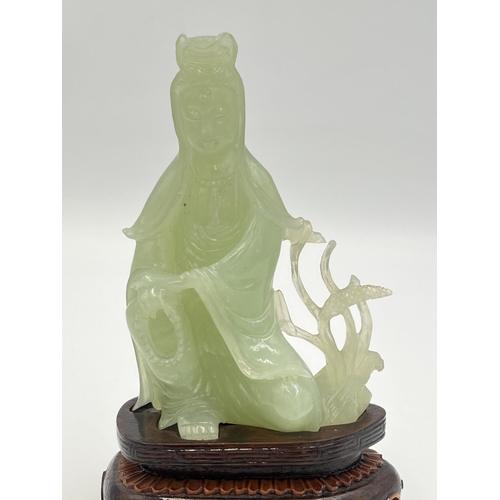 2308 - A hand carved jade Buddha figurine on hardwood stand - approx. 11cm high