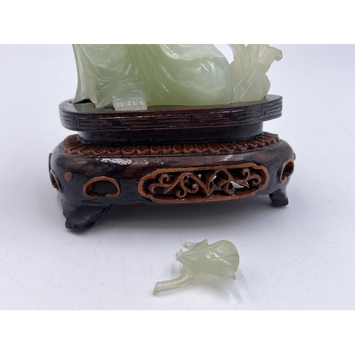 2308 - A hand carved jade Buddha figurine on hardwood stand - approx. 11cm high